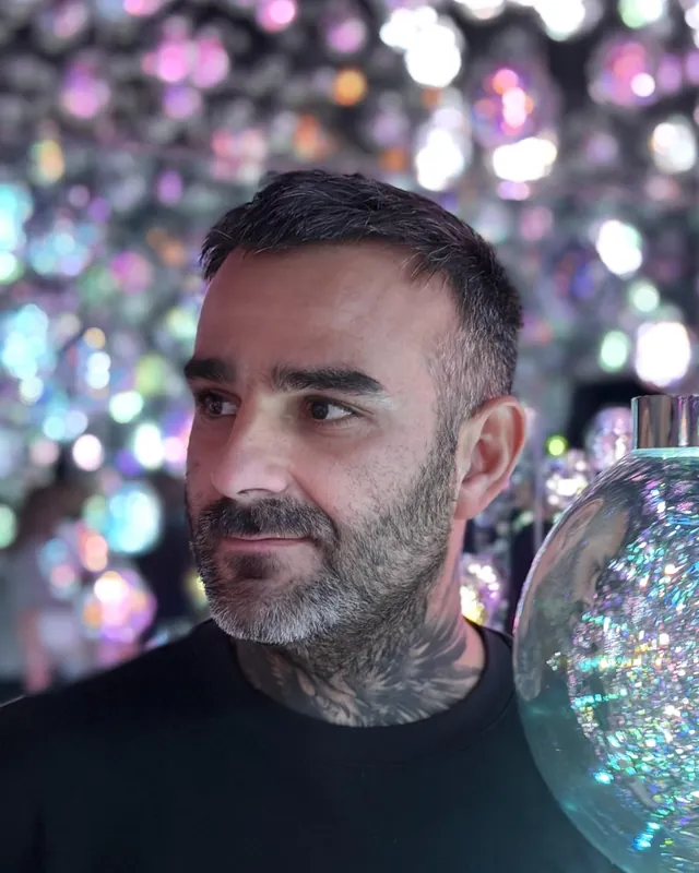 Portrait de Julien Jimenez, éditeur de sites et expert SEO français, devant un décor de lumières colorées